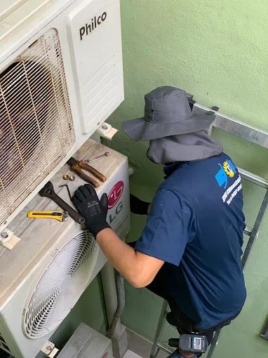 Técnico da JCVV realizando manutenção em um ar condicionado
